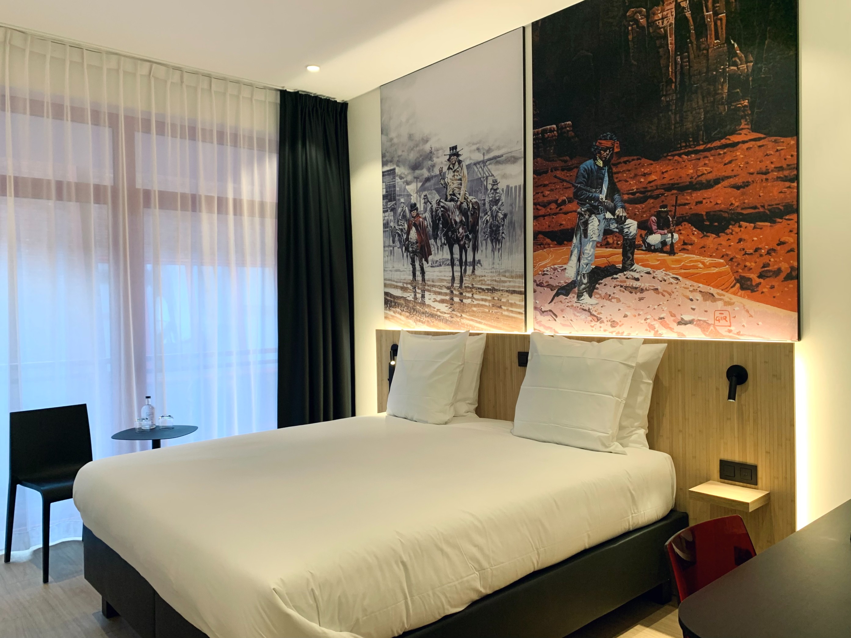 A bright double room with western-themed artwork and contemporary furnishings